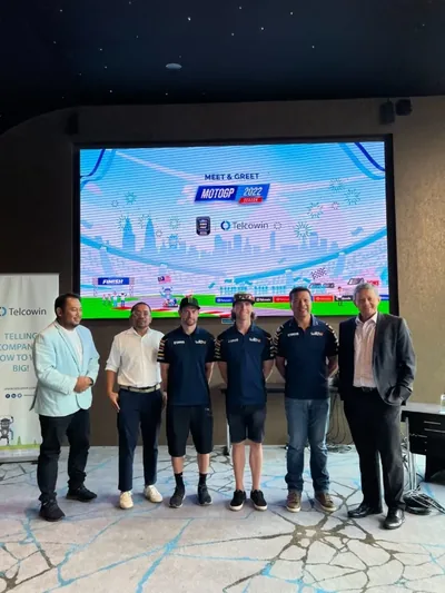 Guests and the riders in front of the Meet & Greet backdrop