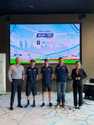 A guest with the two riders and the team principal