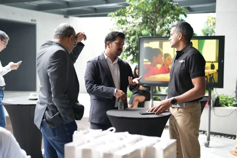 Guests in discussion beside the demo screen during the break